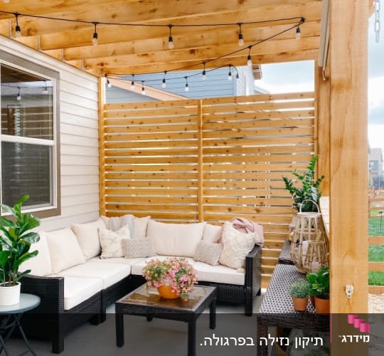 פינת ישיבה מעץ עם ספות וצמחים תחת פרגולה